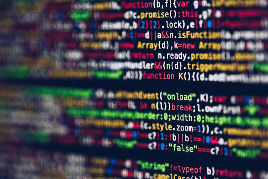 A close-up photograph of a computer screen displaying colorful lines of programming code, with syntax highlighting in shades of red, green, blue, yellow, and white on a dark background. The code consi